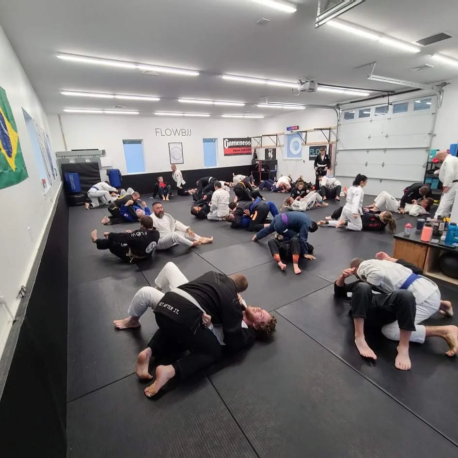 Adults rolling during Jiu Jitsu class at Flow BJJ