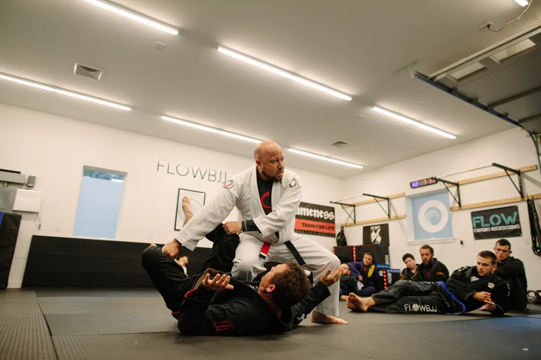 Coach passing guard during adult Jiu Jitsu class at Flow BJJ
