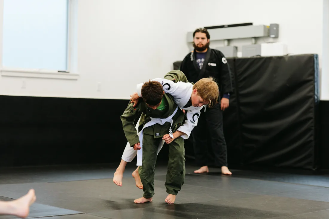 Young student executing a takedown during kids Jiu Jitsu class at Flow BJJ
