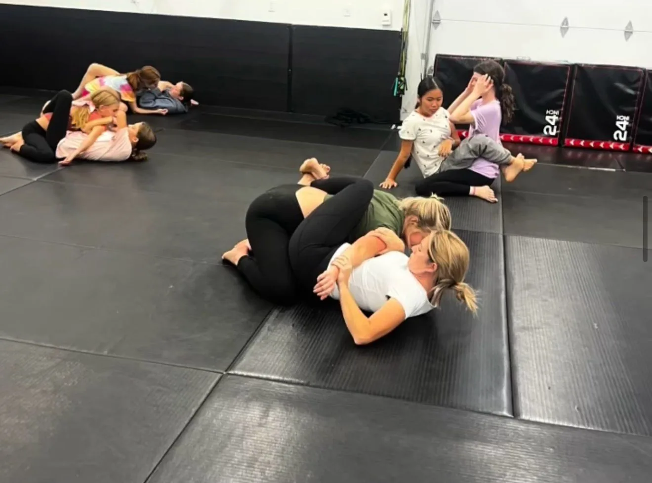 Women drilling and rolling together during women's Jiu Jitsu class at Flow BJJ