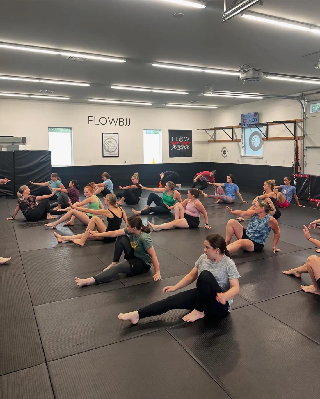 Large women's Jiu Jitsu class warming up at Flow BJJ
